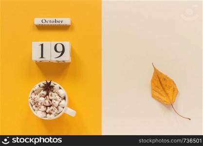 Autumn composition. Wooden calendar October 19, cup of cocoa with marshmallows and yellow autumn leaves on yellow beige background. Top view Flat lay Mockup Concept Hello September.. Autumn composition. Wooden calendar October 19, cup of cocoa with marshmallows and yellow autumn leaves on yellow beige background. Top view Flat lay Mockup Concept Hello September