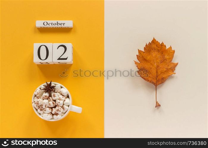 Autumn composition. Wooden calendar October 2, cup of cocoa with marshmallows and yellow autumn leaves on yellow beige background. Top view Flat lay Mockup Concept Hello September.. Autumn composition. Wooden calendar October 2, cup of cocoa with marshmallows and yellow autumn leaves on yellow beige background. Top view Flat lay Mockup Concept Hello September