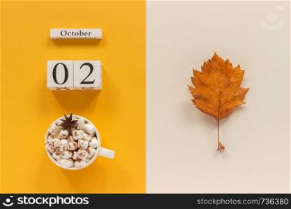 Autumn composition. Wooden calendar October 2, cup of cocoa with marshmallows and yellow autumn leaves on yellow beige background. Top view Flat lay Mockup Concept Hello September.. Autumn composition. Wooden calendar October 2, cup of cocoa with marshmallows and yellow autumn leaves on yellow beige background. Top view Flat lay Mockup Concept Hello September