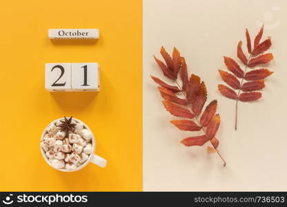 Autumn composition. Wooden calendar October 21, cup of cocoa with marshmallows and red yellow autumn leaves on yellow beige background. Top view Flat lay Mockup Concept Hello September.. Autumn composition. Wooden calendar October 21, cup of cocoa with marshmallows and red yellow autumn leaves on yellow beige background. Top view Flat lay Mockup Concept Hello September