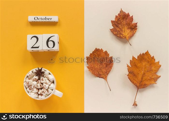 Autumn composition. Wooden calendar October 26, cup of cocoa with marshmallows and yellow autumn leaves on yellow beige background. Top view Flat lay Mockup Concept Hello September.. Autumn composition. Wooden calendar October 26, cup of cocoa with marshmallows and yellow autumn leaves on yellow beige background. Top view Flat lay Mockup Concept Hello September