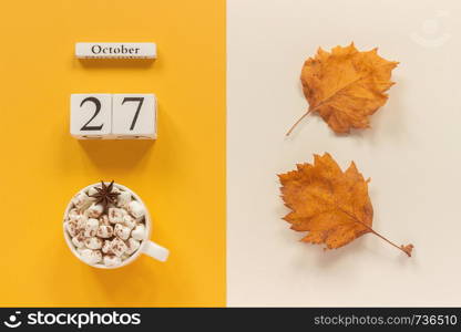 Autumn composition. Wooden calendar October 27, cup of cocoa with marshmallows and yellow autumn leaves on yellow beige background. Top view Flat lay Mockup Concept Hello September.. Autumn composition. Wooden calendar October 27, cup of cocoa with marshmallows and yellow autumn leaves on yellow beige background. Top view Flat lay Mockup Concept Hello September