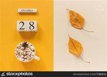 Autumn composition. Wooden calendar October 28, cup of cocoa with marshmallows and yellow autumn leaves on yellow beige background. Top view Flat lay Mockup Concept Hello September.. Autumn composition. Wooden calendar October 28, cup of cocoa with marshmallows and yellow autumn leaves on yellow beige background. Top view Flat lay Mockup Concept Hello September