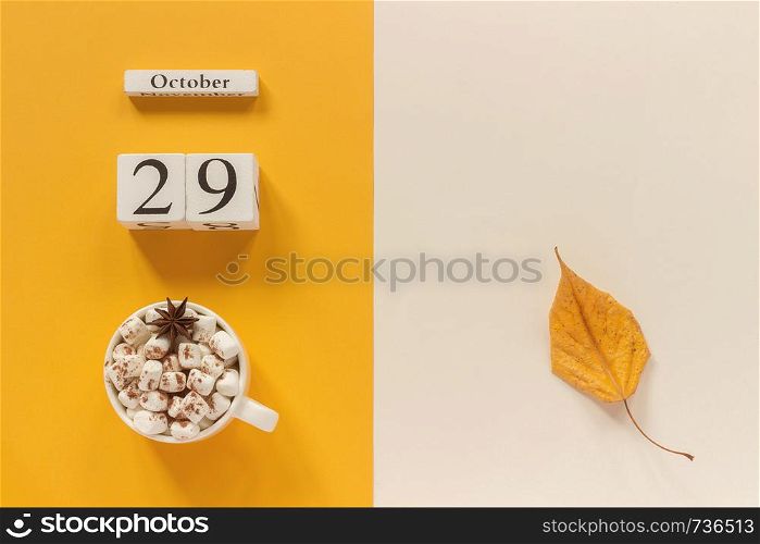 Autumn composition. Wooden calendar October 29, cup of cocoa with marshmallows and yellow autumn leaves on yellow beige background. Top view Flat lay Mockup Concept Hello September.. Autumn composition. Wooden calendar October 29, cup of cocoa with marshmallows and yellow autumn leaves on yellow beige background. Top view Flat lay Mockup Concept Hello September