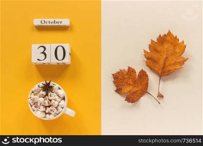 Autumn composition. Wooden calendar October 30, cup of cocoa with marshmallows and yellow autumn leaves on yellow beige background. Top view Flat lay Mockup Concept Hello September.. Autumn composition. Wooden calendar October 30, cup of cocoa with marshmallows and yellow autumn leaves on yellow beige background. Top view Flat lay Mockup Concept Hello September