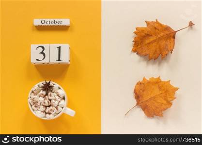 Autumn composition. Wooden calendar October 31, cup of cocoa with marshmallows and yellow autumn leaves on yellow beige background. Top view Flat lay Mockup Concept Hello September.. Autumn composition. Wooden calendar October 31, cup of cocoa with marshmallows and yellow autumn leaves on yellow beige background. Top view Flat lay Mockup Concept Hello September