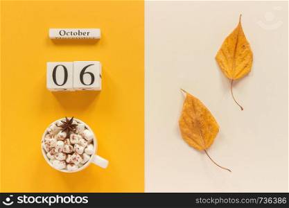 Autumn composition. Wooden calendar October 6 , cup of cocoa with marshmallows and yellow autumn leaves on yellow beige background. Top view Flat lay Mockup Concept Hello September.. Autumn composition. Wooden calendar October 6, cup of cocoa with marshmallows and yellow autumn leaves on yellow beige background. Top view Flat lay Mockup Concept Hello September
