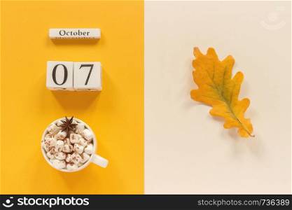 Autumn composition. Wooden calendar October 7, cup of cocoa with marshmallows and yellow autumn leaves on yellow beige background. Top view Flat lay Mockup Concept Hello September.. Autumn composition. Wooden calendar October 7, cup of cocoa with marshmallows and yellow autumn leaves on yellow beige background. Top view Flat lay Mockup Concept Hello September