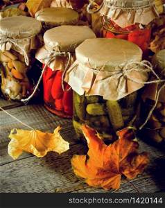 Autumn concept. Preserved food in glass jars on a wooden board. Marinated food. Autumn concept. Preserved food in glass jars