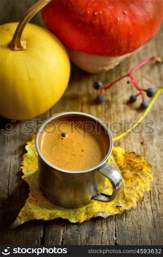 Autumn cup of coffee and pumpkin on wooden background