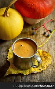 Autumn cup of coffee and pumpkin on wooden background