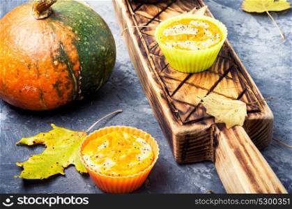 Autumn cupcake with pumpkin. Pumpkin muffins on a background with autumn leaves