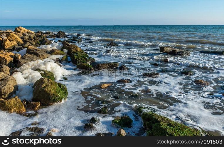 Autumn day by the sea near the village of Fontanka, Odessa region, Ukraine. Sea foam and stones on the shore