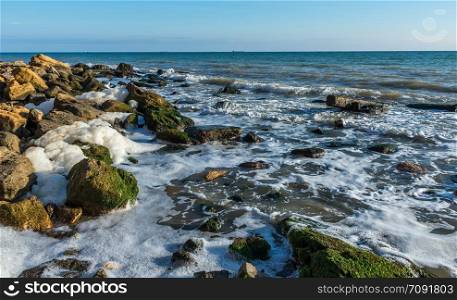 Autumn day by the sea near the village of Fontanka, Odessa region, Ukraine. Sea foam and stones on the shore