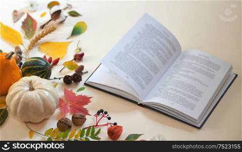 Autumn decoration and open book on table