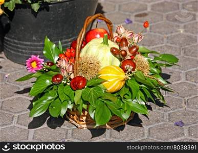 Autumn decorations with gourds, chestnuts, apples, hips and green leaves