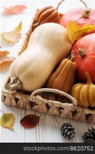 Autumn decorative pumpkins with fall leaves on wooden background. Thanksgiving or halloween holiday, harvest concept.