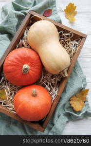 Autumn decorative pumpkins with fall leaves on wooden background. Thanksgiving or halloween holiday, harvest concept.