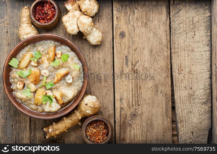 Autumn dietary artichoke cream soup.Soup of Jerusalem artichoke on rustic background. Vegetarian cream soup