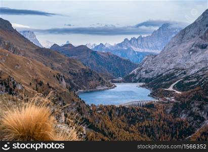 Autumn Dolomites mountain view from hiking path betwen Pordoi Pass and Fedaia Lake, Trentino, Italy. Picturesque traveling, seasonal, nature and countryside beauty concept scene.