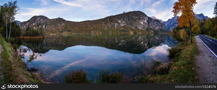 Autumn evening alpine view. Peaceful mountain lake with clear transparent water and reflections. Almsee lake, Upper Austria. Panorama.
