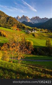 Autumn evening Santa Magdalena famous Italy Dolomites village view in front of the Geisler or Odle Dolomites mountain rocks. Picturesque traveling and countryside beauty concept background.