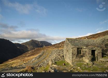 Autumn Fall landscape image of old bothy in Lake Districtr mountains near Buttermere with Haystacks and High Stiel in the distance