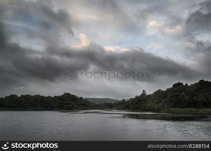 Autumn Fall landscape image stormy sky over calm lake