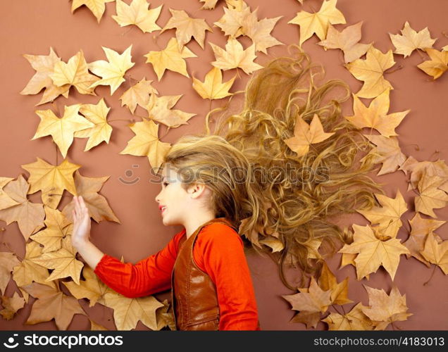 autumn fall little blond girl on dried tree leaves