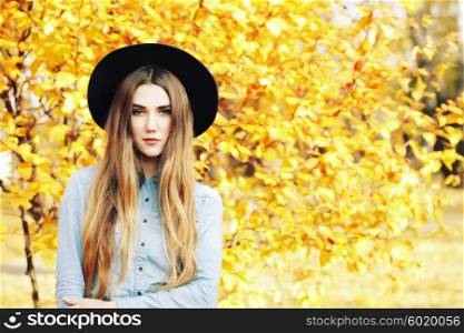 Autumn fashion portrait of glamour sensual young stylish lady wearing trendy fall outfit, black hat, denim shirt and leather skirt. Beautifull model with long healthy colorful ombre hair outdoors.