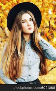 Autumn fashion portrait of glamour sensual young stylish lady wearing trendy fall outfit, black hat, denim shirt and leather skirt. Beautifull model with long healthy colorful ombre hair outdoors.