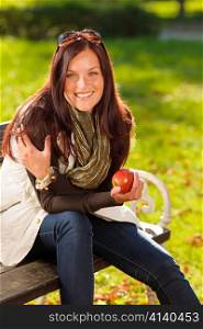 Autumn fashion smiling beautiful woman eat apple sunset nature park