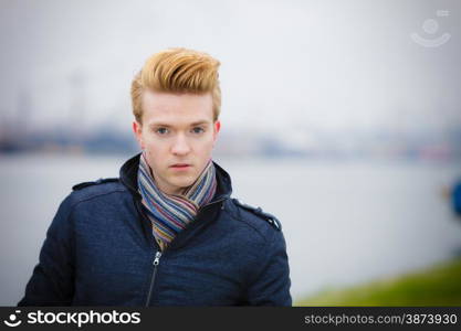 Autumn fashion. Young handsome man model casual style hair styling outdoor against overcast sky, cold autumnal foggy day