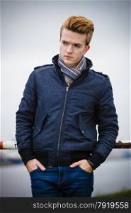 Autumn fashion. Young handsome man model casual style hair styling outdoor against overcast sky, cold autumnal foggy day