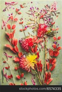 Autumn flowers and leaves flat lay composing, top view. Fall floral still life with chrysanthemums and red orange branches.