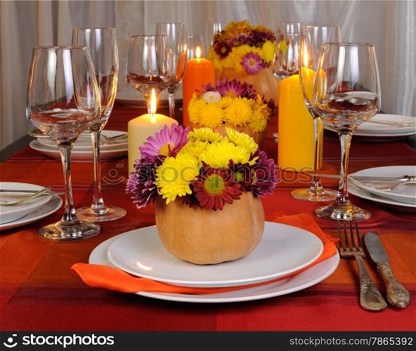 Autumn flowers in a vase of pumpkins as decor element tableware