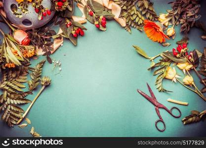 Autumn flowers with scissors on florist workspace for arrangements and decor, top view, frame