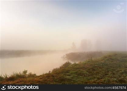 Autumn foggy morning. Dawn on the misty calm river