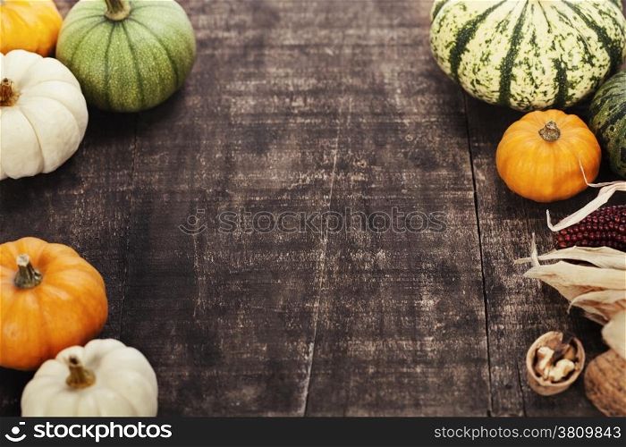 Autumn frame from pumpkins and corn on old wooden table. Thanksgiving day concept