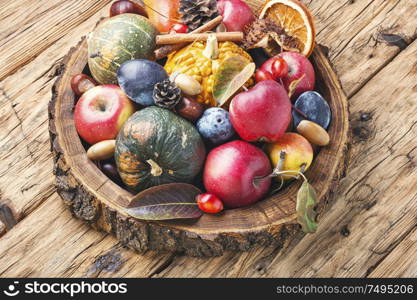 Autumn fruits and pumpkins with fallen leaves.Autumn harvest on wooden table. Beautiful autumn composition