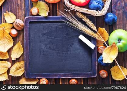 autumn harvest and chalkboard for note on a table