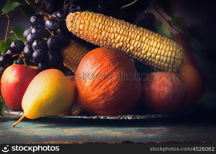 Autumn harvest concept. Fall fruits and vegetables on dark rustic kitchen table, close up