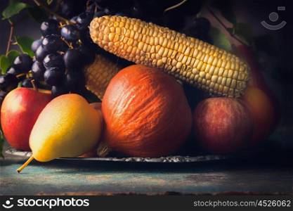 Autumn harvest concept. Fall fruits and vegetables on dark rustic kitchen table, close up