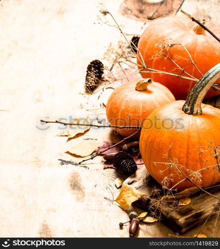 Autumn harvest. Ripe pumpkin with leaves. On wooden background.. Autumn harvest. Ripe pumpkin with leaves.