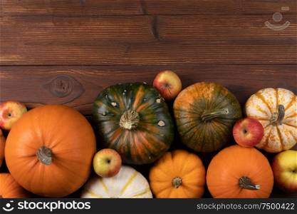 Autumn harvest still life with pumpkins and apples on wooden background , top view. Autumn harvest on wooden table