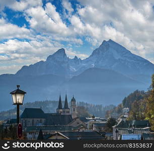 Autumn hazy day famous Bavarian prealps Berchtesgaden town and mount Watzmann silhouette in contra light, Germany