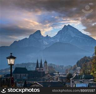 Autumn hazy day famous Bavarian prealps Berchtesgaden town and mount Watzmann silhouette in contra light, Germany