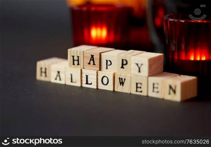 autumn holidays and decorations concept - wooden toy blocks with happy halloween letters on table. wooden toy blocks with happy halloween letters