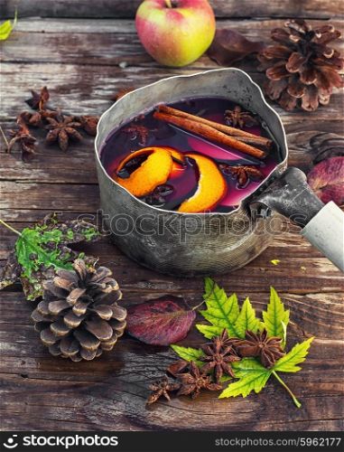 Autumn is an alcoholic beverage with wine. sangria in an old-fashioned bowler hat on background strewn with autumn leaves and cones.