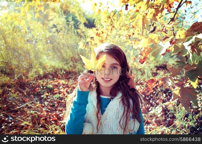 Autumn kid girl relaxed in fall forest with leaves